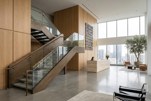 Modern lobby staircase with wood paneling and glass railings